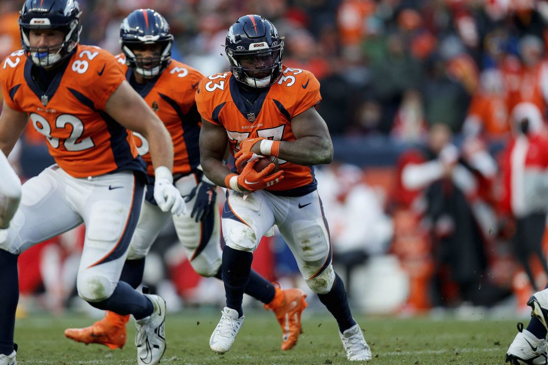 Oct 29, 2023; Denver, Colorado, USA; Denver Broncos running back Javonte Williams (33) runs the ball as tight end Adam Trautman (82) defends in the fourth quarter against the Kansas City Chiefs at Empower Field at Mile High. Mandatory Credit: Isaiah J. Downing-USA TODAY Sports