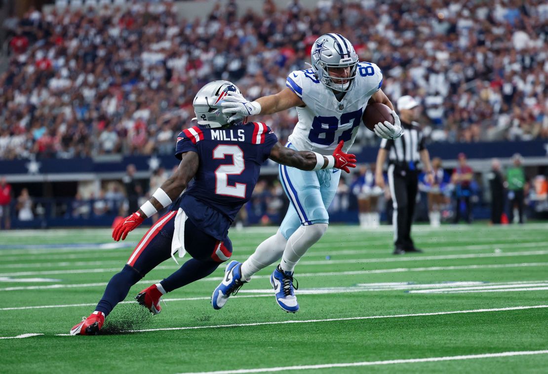 Oct 1, 2023; Arlington, Texas, USA;  Dallas Cowboys tight end Jake Ferguson (87) runs with the ball as New England Patriots cornerback Jalen Mills (2) defends during the first quarter at AT&T Stadium. Mandatory Credit: Kevin Jairaj-USA TODAY Sports