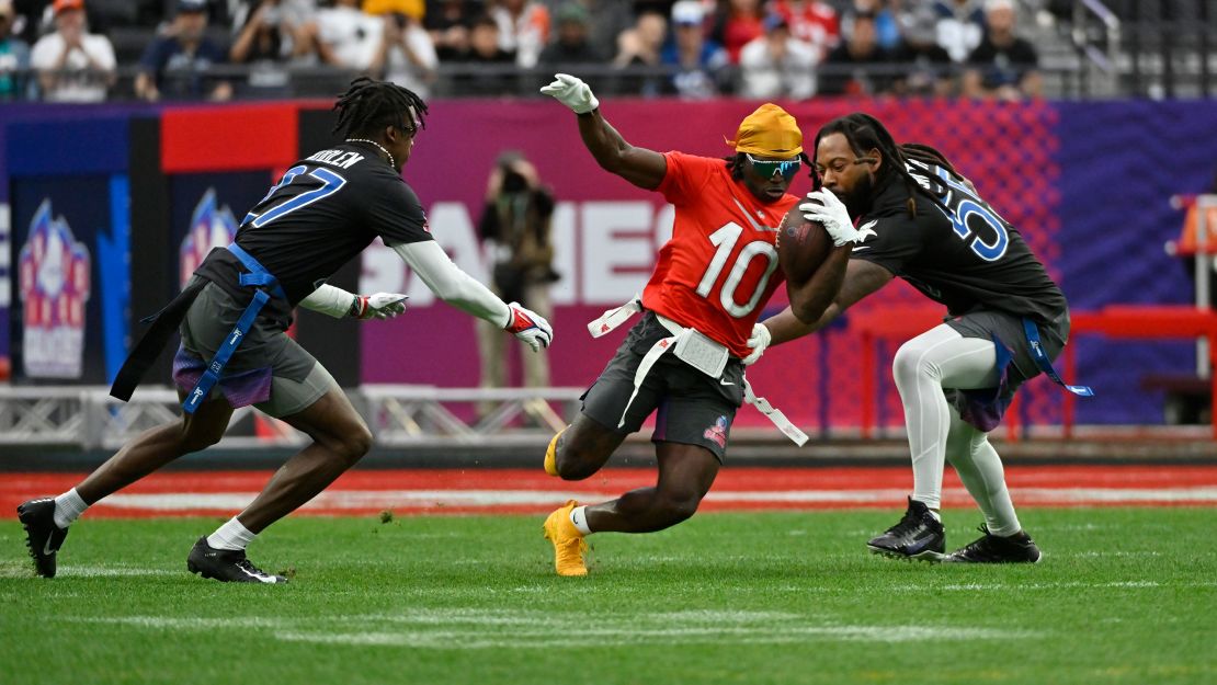 FILE - AFC wide receiver Tyreek Hill (10) of the Miami Dolphins carries the ball against NFC cornerback Tariq Woolen (27) of the Seattle Seahawks and outside linebacker Za'Darius Smith (55) of the Minnesota Vikings during the flag football event at the NFL Pro Bowl, Feb. 5, 2023, in Las Vegas. Flag football took a key step toward becoming an Olympic sport in 2028, a victory for the NFL and organizers in Los Angeles who will bring a distinctly American sport to the Summer Games as they return to the United States for the first time in 32 years. (AP Photo/David Becker, File)