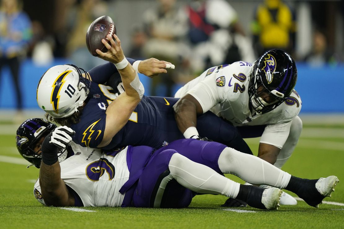 Los Angeles Chargers quarterback Justin Herbert (10) is sacked by Baltimore Ravens defensive tackle Travis Jones, bottom, and defensive tackle Justin Madubuike during the first half of an NFL football game Sunday, Nov. 26, 2023, in Inglewood, Calif.(AP Photo/Ryan Sun)