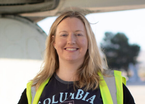 A photo of Róisín Commane standing in front of a DC-8 aircraft.