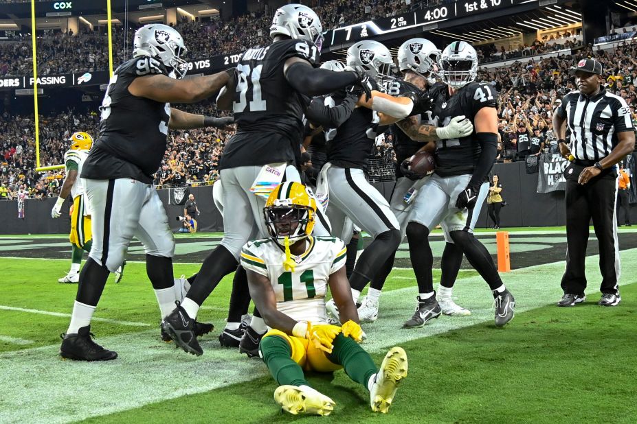 Green Bay Packers wide receiver Jayden Reed sits on the sideline as Las Vegas Raiders' Robert Spillane is congratulated after his interception on October 9. The Raiders beat the Packers 17-13.