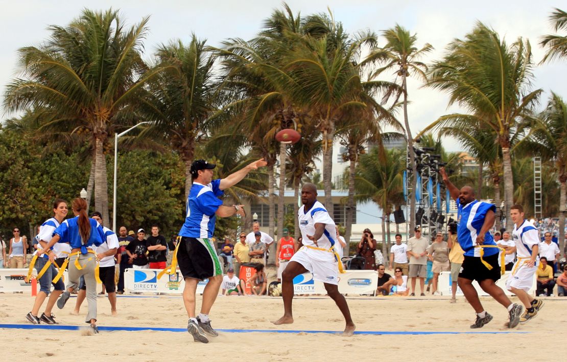 Pro Football Hall of Fame quarterback Steve Young, left center, throws a pass during the first annual DirecTV Celebrity Beach Bowl flag football game, Thursday, Feb. 1, 2007, in Miami Beach. (AP Photo/Luis M. Alvarez)