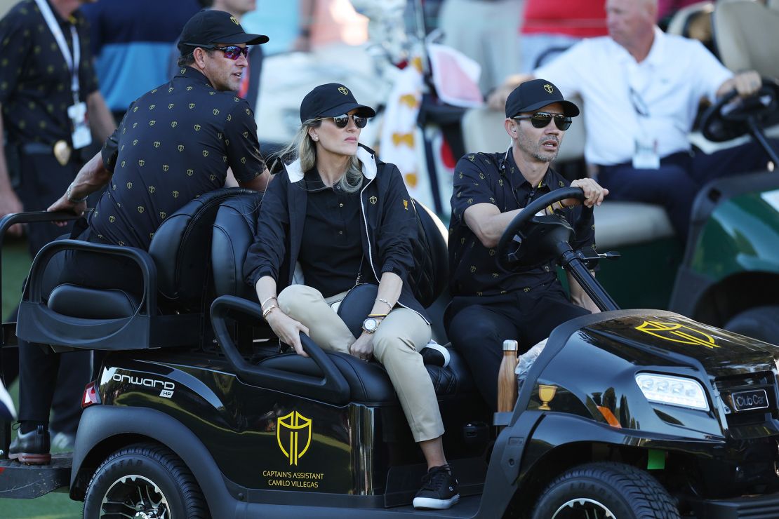 CHARLOTTE, NORTH CAROLINA - SEPTEMBER 23: Assistant Captain Camilo Villegas of the International Team, Adam Scott of Australia and Maria Ochoa Mora, wife of Villegas, ride in a golf cart during Friday four-ball matches on day two of the 2022 Presidents Cup at Quail Hollow Country Club on September 23, 2022 in Charlotte, North Carolina. (Photo by Rob Carr/Getty Images)