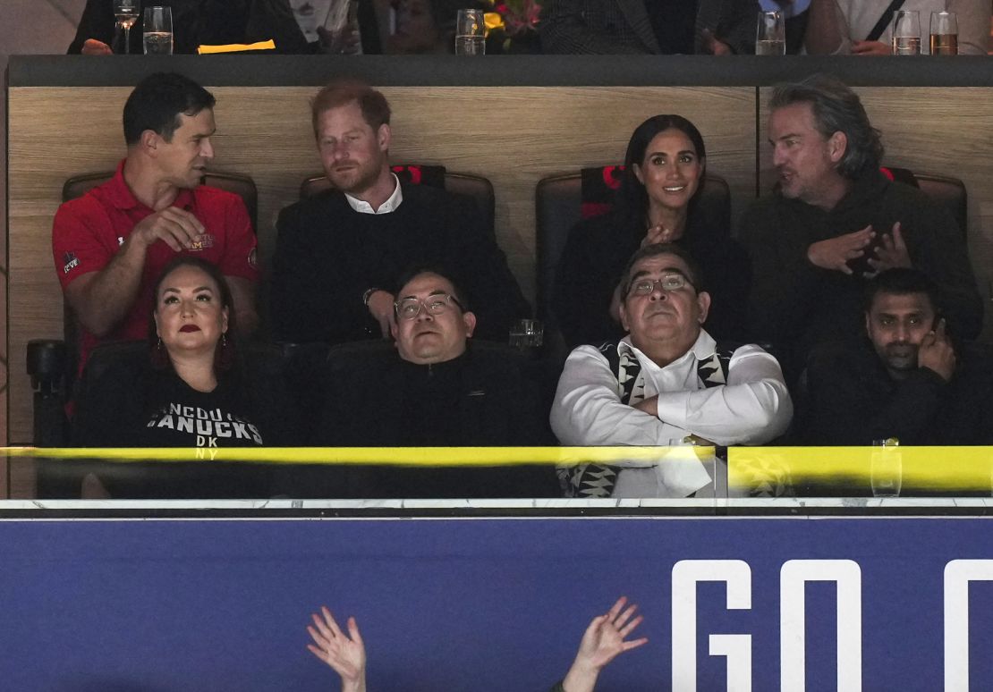 Prince Harry, second from top left, and Meghan Markle, second from top right, the Duke and Duchess of Sussex, attend the first period of an NHL hockey game between the Vancouver Canucks and the San Jose Sharks in Vancouver, British Columbia, Monday, Nov. 20, 2023. (Darryl Dyck/The Canadian Press via AP)