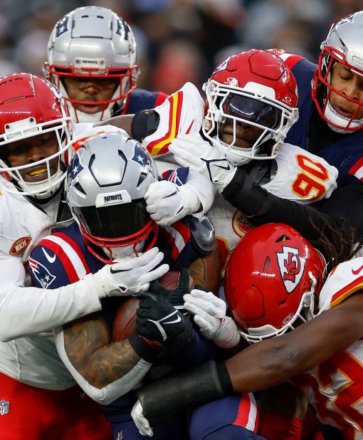 Chamarri Conner, Charles Omenihu and Nick Bolton of the Kansas City Chiefs tackle New England Patriots running back Ezekiel Elliott. The Chiefs won 27-17.