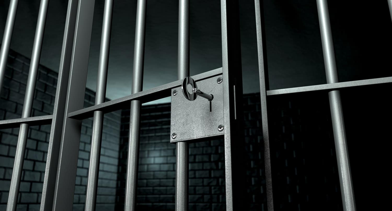 A jail cell door with a key in its lock.