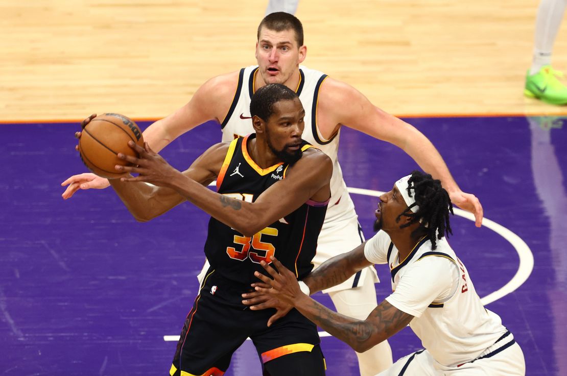 Dec 1, 2023; Phoenix, Arizona, USA; Phoenix Suns forward Kevin Durant (35) controls the ball under pressure from Denver Nuggets guard Kentavious Caldwell-Pope (5) and center Nikola Jokic (15) in the second half at Footprint Center.