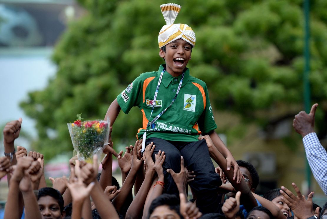 TOPSHOT - Indian chess prodigy Rameshbabu Praggnanandhaa, 12, laughs as he is celebrated by his school friends upon his arrival back to his school in Chennai on June 26, 2018 after becoming the world's second youngest chess grandmaster ever. Rameshbabu Praggnanandhaa, the son of a bank employee from the southern city of Chennai, achieved the feat with some aggressive play at an event in northern Italy that ended June 24. (Photo by ARUN SANKAR / AFP) / "The erroneous mention[s] appearing in the metadata of this photo by ARUN SANKAR has been modified in AFP systems in the following manner: [June] instead of [July]. Please immediately remove the erroneous mention[s] from all your online services and delete it (them) from your servers. If you have been authorized by AFP to distribute it (them) to third parties, please ensure that the same actions are carried out by them. Failure to promptly comply with these instructions will entail liability on your part for any continued or post notification usage. Therefore we thank you very much for all your attention and prompt action. We are sorry for the inconvenience this notification may cause and remain at your disposal for any further information you may require." (Photo by ARUN SANKAR/AFP via Getty Images)