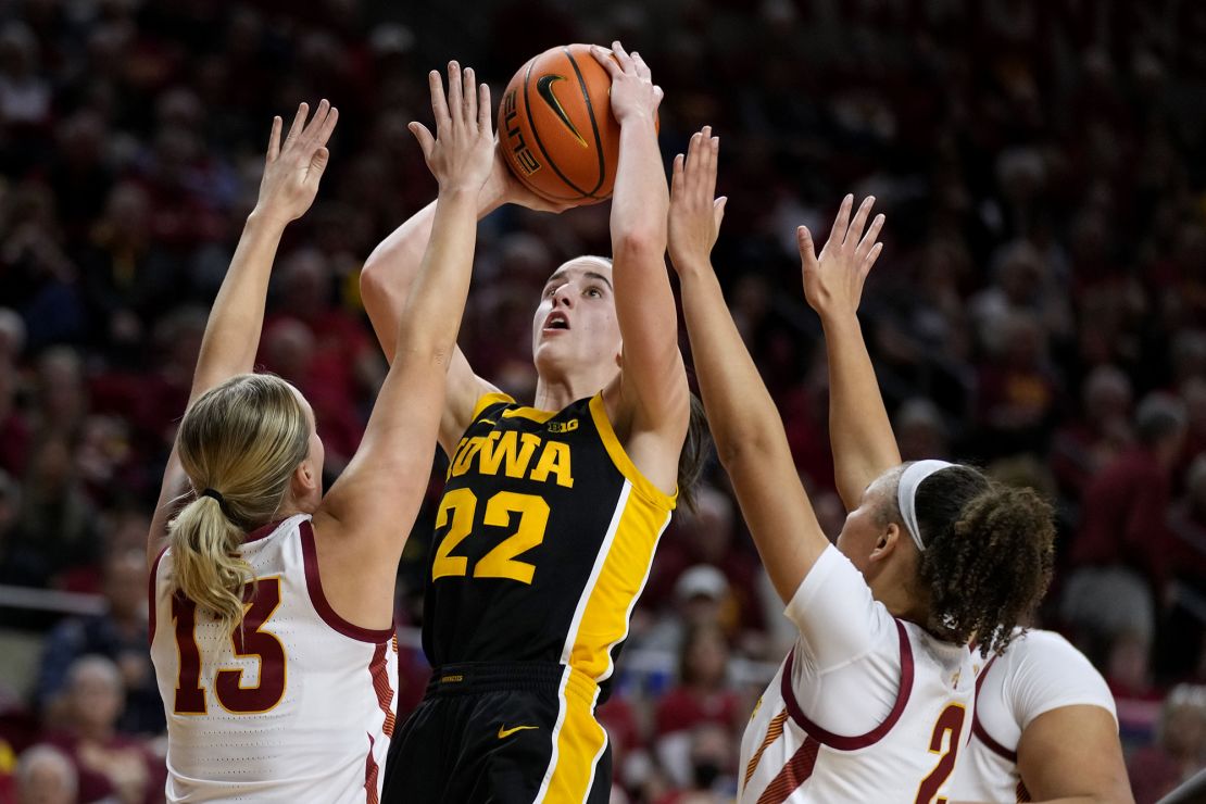 Iowa guard Caitlin Clark (22) shoots between Iowa State guard Hannah Belanger (13) and guard Arianna Jackson (2) during the first half of an NCAA college basketball game, Wednesday, Dec. 6, 2023, in Ames, Iowa. (AP Photo/Charlie Neibergall)