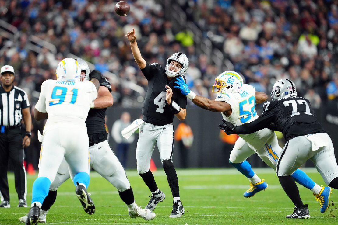 Dec 14, 2023; Paradise, Nevada, USA;  Las Vegas Raiders quarterback Aidan O'Connell (4) throws a pass under pressure from Los Angeles Chargers linebacker Khalil Mack (52) in the second quarter at Allegiant Stadium. Mandatory Credit: Stephen R. Sylvanie-USA TODAY Sports