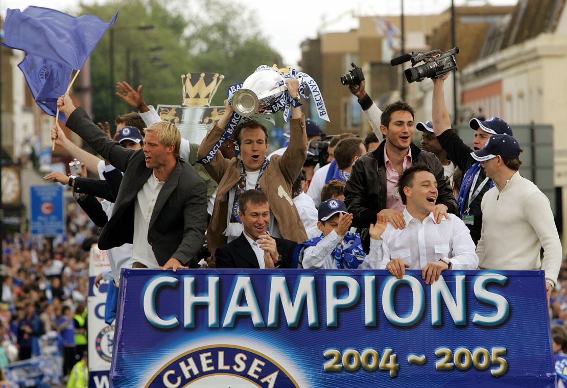 LONDON, UNITED KINGDOM:  Chelsea striker Arjen Robben (C) holds the Barclay's Premiership trophy aloft as he rides on an open-top bus with Chelsea owner Roman Abramovich (C front), Eidur Gudjohnsen (L), Frank Lampard (2nd R) and John Terry (2nd R front) and other teammates during a parade  in west London 22 May  2005. Chelsea won the Premiership for  the 2004/2005 season , their first league trophy in 50 years.   AFP PHOTO  / ODD ANDERSEN  (Photo credit should read ODD ANDERSEN/AFP via Getty Images)