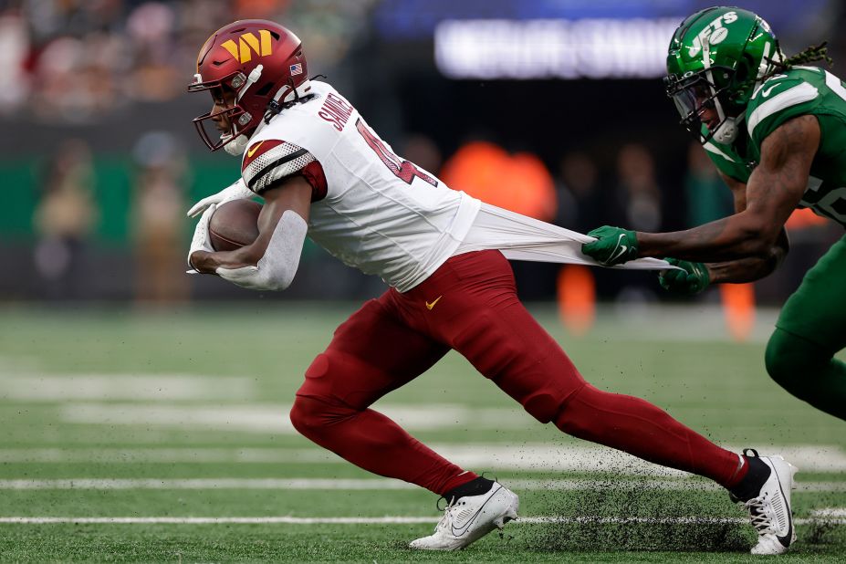 New York Jets linebacker Quincy Williams grabs the jersey of Washington Commanders wide receiver Curtis Samuel on December 24. The Jets beat the Commanders 30-28.