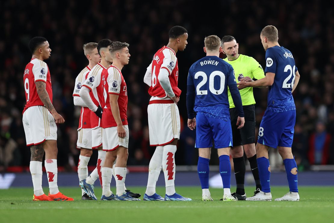 LONDON, ENGLAND - DECEMBER 28: Referee Michael Oliver speaks with Leandro Trossard and Gabriel of Arsenal and Jarrod Bowen and Tomas Soucek of West Ham United as a VAR Review takes place, following the goal the first goal for West Ham United by Tomas Soucek of West Ham United, during the Premier League match between Arsenal FC and West Ham United at Emirates Stadium on December 28, 2023 in London, England. (Photo by Catherine Ivill/Getty Images)