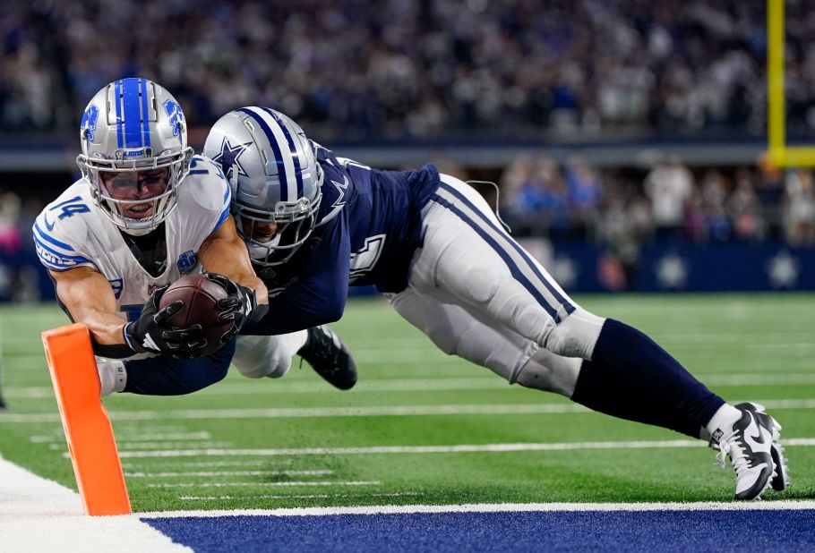 Detroit Lions wide receiver Amon-Ra St. Brown scores a touchdown as Dallas Cowboys cornerback Stephon Gilmore tries to stop him.