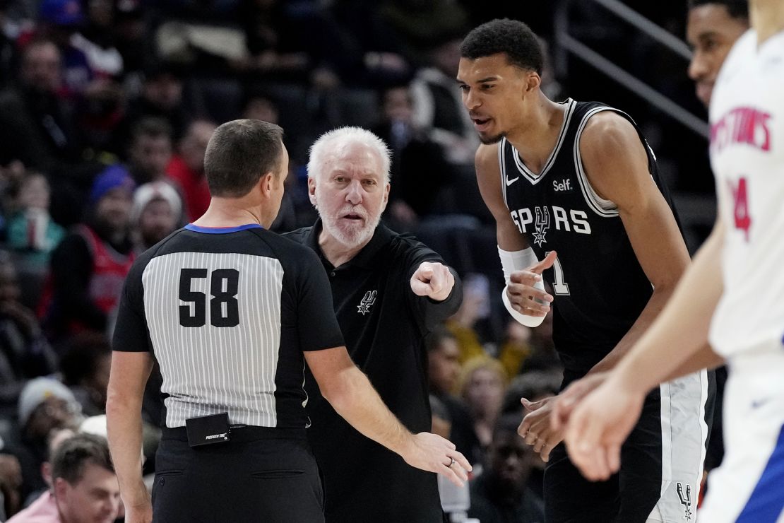 San Antonio Spurs head coach Gregg Popovich and center Victor Wembanyama (1) dispute a call with referee Josh Tiven (58) during the first half of an NBA basketball game against the Detroit Pistons, Wednesday, Jan. 10, 2024, in Detroit. (AP Photo/Carlos Osorio)