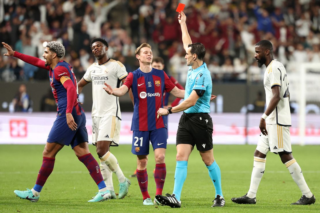 Spanish match referee Juan Martinez Munuera shows Barcelona's Uruguayan defender #04 Ronald Araujo a red card during the Spanish Super Cup final football match between Real Madrid and Barcelona at the Al-Awwal Park Stadium in Riyadh, on January 14, 2024. (Photo by Giuseppe CACACE / AFP) (Photo by GIUSEPPE CACACE/AFP via Getty Images)