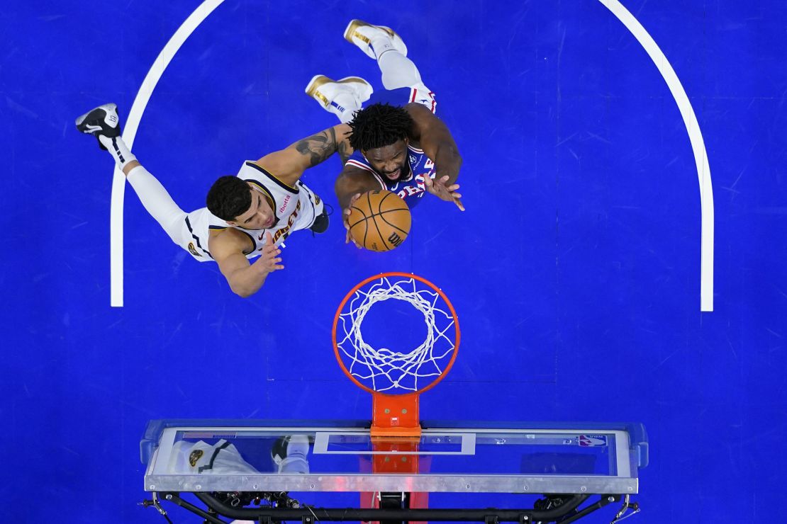 Philadelphia 76ers' Joel Embiid, right, goes up for a shot against Denver Nuggets' Michael Porter Jr. during the first half of an NBA basketball game, Tuesday, Jan. 16, 2024, in Philadelphia. (AP Photo/Matt Slocum)