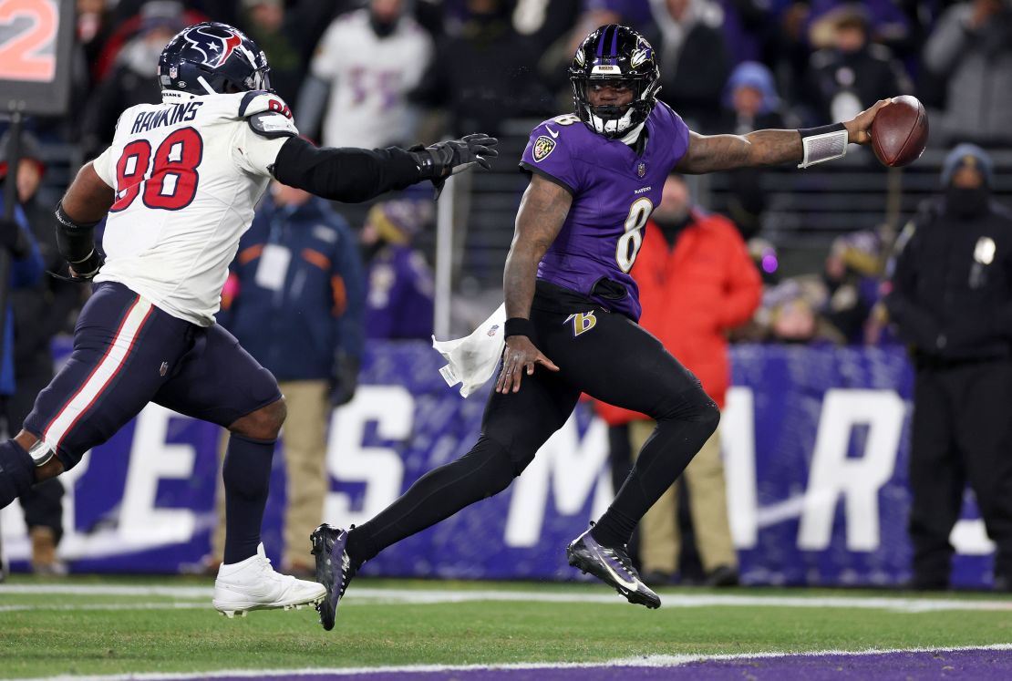 BALTIMORE, MARYLAND - JANUARY 20: Lamar Jackson #8 of the Baltimore Ravens scores an 8 yard touchdown against Sheldon Rankins #98 of the Houston Texans during the fourth quarter in the AFC Divisional Playoff game at M&T Bank Stadium on January 20, 2024 in Baltimore, Maryland. (Photo by Patrick Smith/Getty Images)