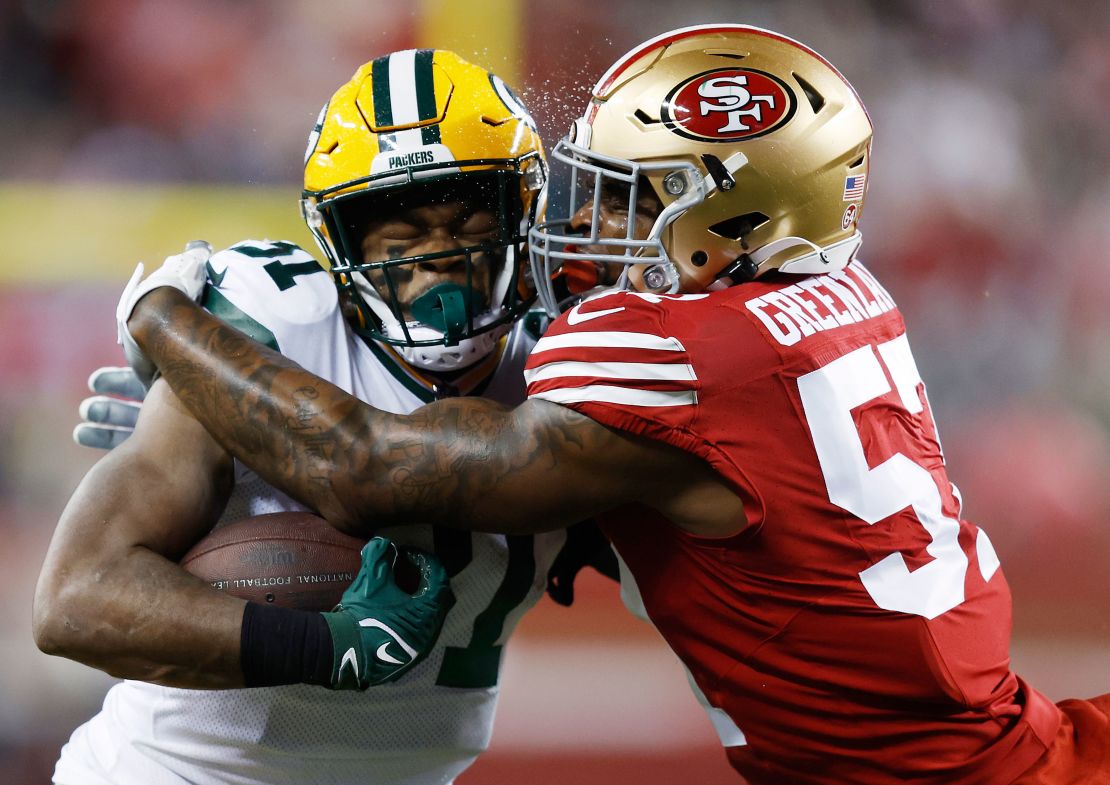 SANTA CLARA, CALIFORNIA - JANUARY 20: Dre Greenlaw #57 of the San Francisco 49ers tackles Emanuel Wilson #31 of the Green Bay Packers during the first half in the NFC Divisional Playoffs at Levi's Stadium on January 20, 2024 in Santa Clara, California. (Photo by Lachlan Cunningham/Getty Images)