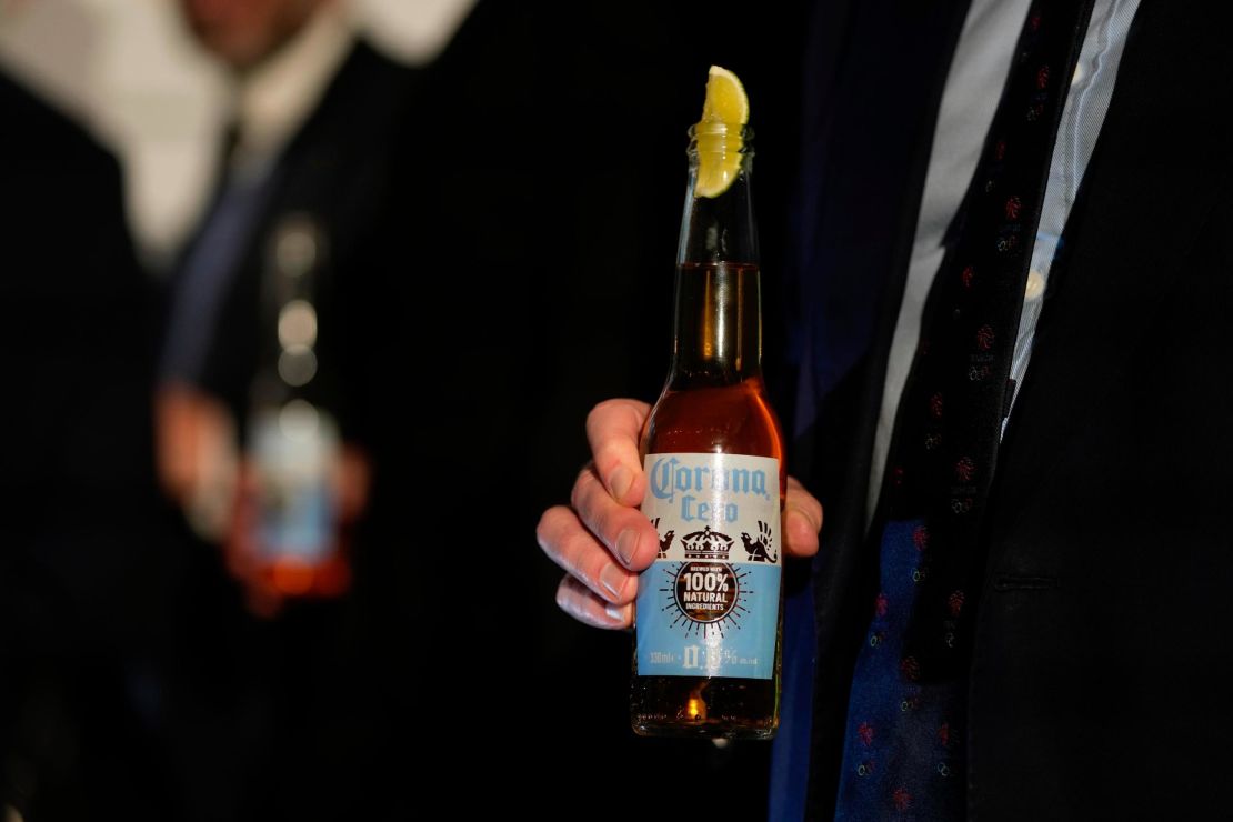 Britain Olympics Beer sponsor. A guest holds a bottle of Corona Cero Alcohol Free Beer at a news conference in London, Friday, Jan. 12, 2024. The International Olympic Committee has signed Anheuser-Busch InBev as the first beer brand in the 40-year history of its sponsorship program, which earns billions of dollars for the organization and international sports.