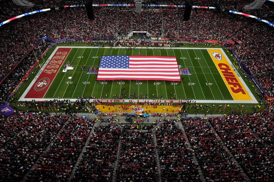 The American flag is unfurled as Reba McEntire performs the national anthem before the game.