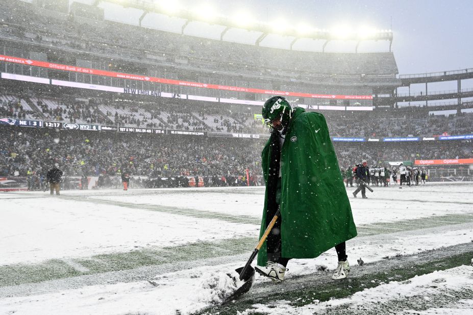 New York Jets long snapper Thomas Hennessy shovels snow along the sideline during a game at New England on January 7. The Jets won 17-3, but both teams finished the season well out of the playoff picture.