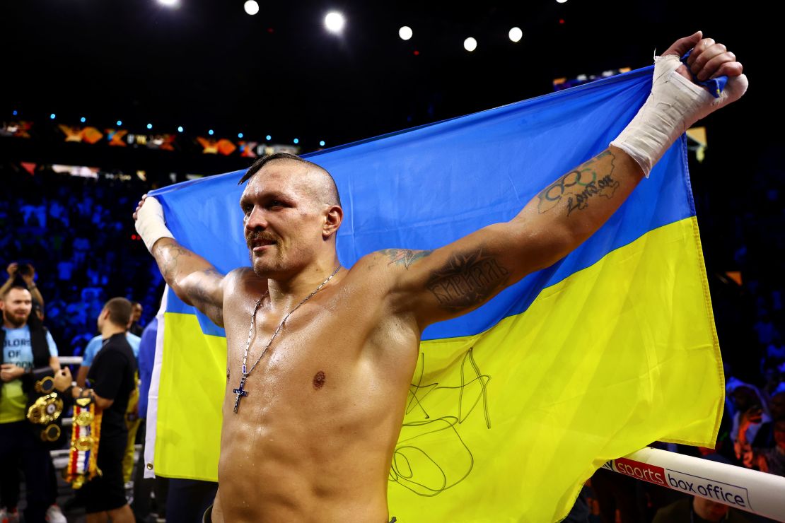 Usyk celebrates with an Ukrainian flag after beating Anthony Joshua in 2022.