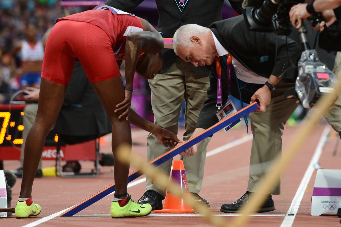 Judges inspect the take-off board at the 2012 London Olympics.