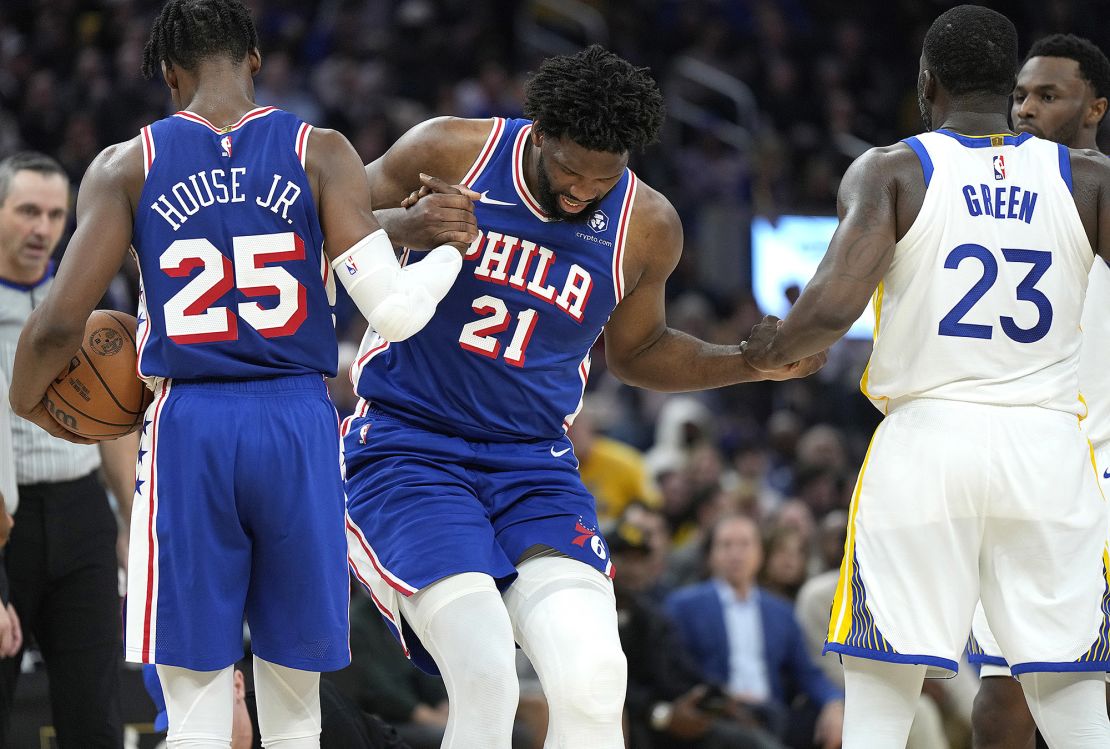 Embiid is helped off the floor during the game against the Warriors.