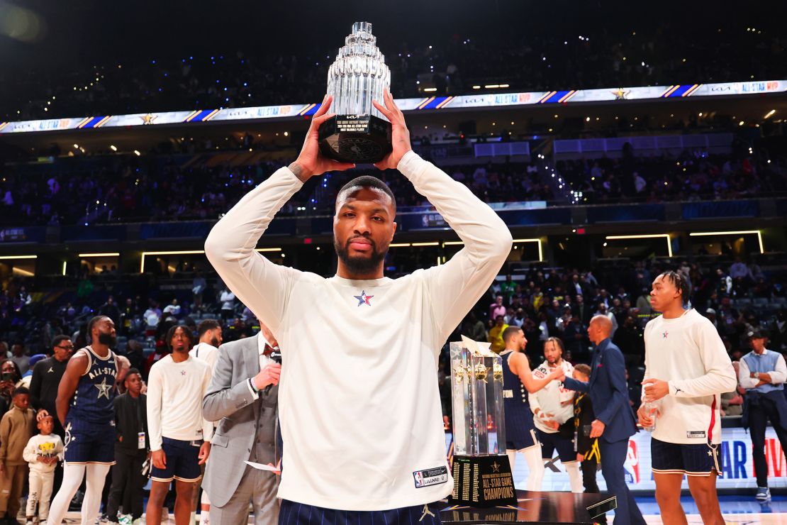 Lillard lifts the Kobe Bryant All-Star MVP trophy.