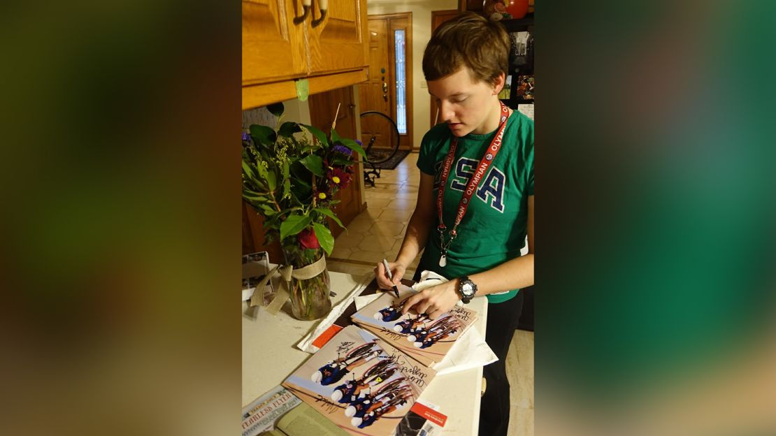 Kelly signing pictures from the Olympics for fans in the family home in Arden Hills, Minnesota. Kelly continually received requests for autographed pictures from fans, particularly from Europe, and a surprising number from Germany, her father said, adding that she always responded.