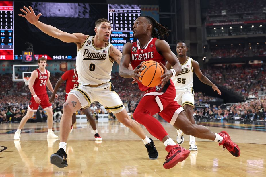 DJ Horne of NC State dribbles the ball past Purdue's Mason Gillis.