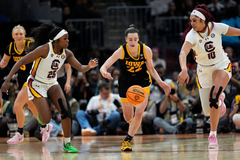 Clark runs down a loose ball between South Carolina guard Raven Johnson and center Cardoso.