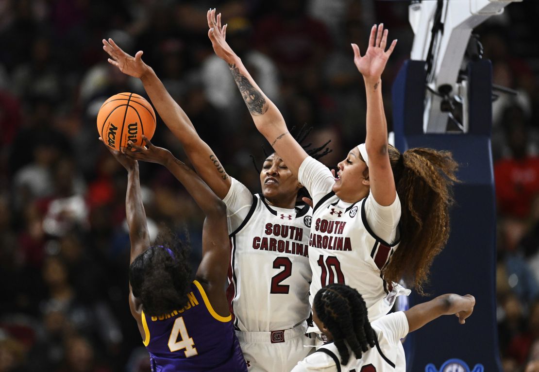 Watkins (#2) and Cardoso (#10) block a shot attempt by LSU's Flau'jae Johnson.