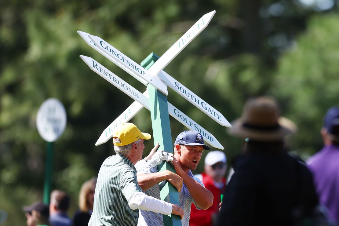 AUGUSTA, GEORGIA - APRIL 12: Bryson DeChambeau of the United States moves a sign while preparing to play his second shot on the 13th hole from the 14th fairway during the second round of the 2024 Masters Tournament at Augusta National Golf Club on April 12, 2024 in Augusta, Georgia. (Photo by Maddie Meyer/Getty Images)