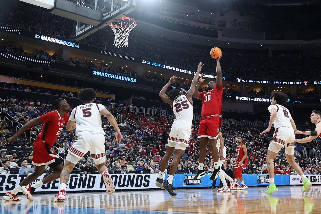 PITTSBURGH, PENNSYLVANIA - MARCH 21: DJ Burns Jr. #30 of the North Carolina State Wolfpack shoots against Robert Jennings #25 of the Texas Tech Red Raiders during the first half in the first round of the NCAA Men's Basketball Tournament at PPG PAINTS Arena on March 21, 2024 in Pittsburgh, Pennsylvania. (Photo by Tim Nwachukwu/Getty Images)