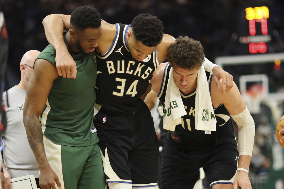 Antetokounmpo is helped off the court by teammates after suffering a calf injury.