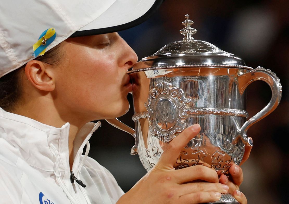 Świątek kisses the trophy after winning the 2022 French Open.