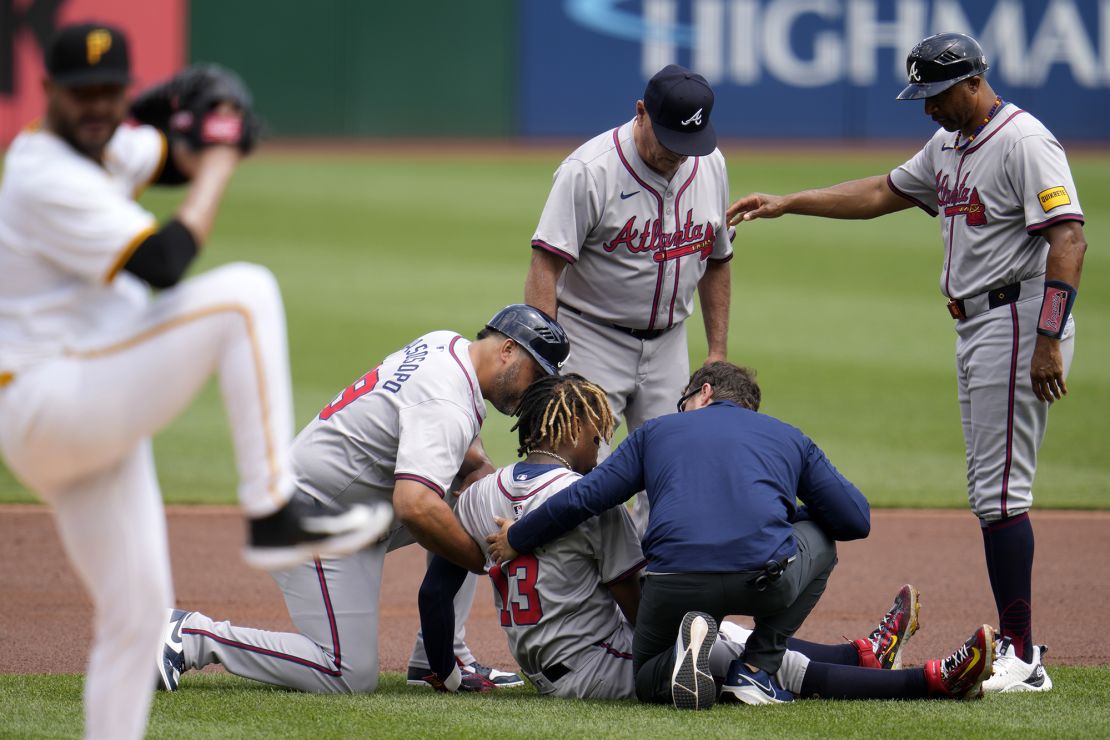 Acuña Jr. (13) is tended to after being injured while running the bases in the first inning against the Pittsburgh Pirates on May 26.