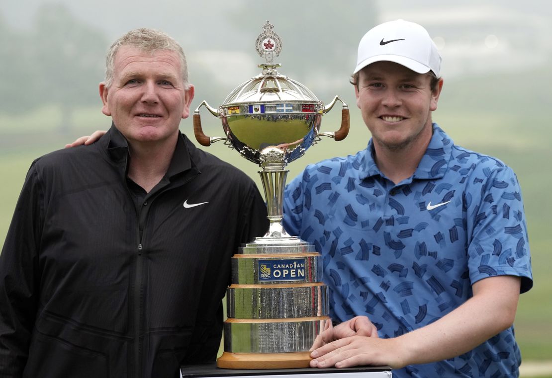 Father and son pose with the trophy.