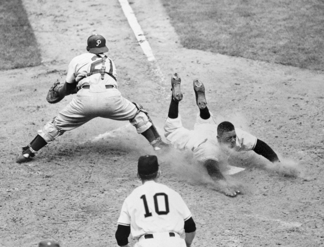 Willie Mays of the New York Giants slides safely into the plate on Wes Westrum's bases-full single in the sixth inning against the Philadelphia Phillies at the Polo Grounds, New York.