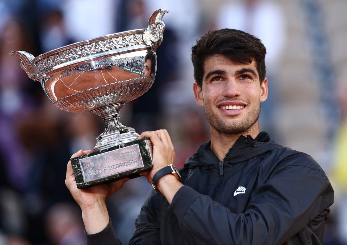 Alcaraz celebrates with the French Open trophy.