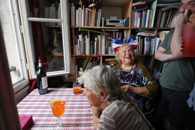 Parisians wait inside their apartment to watch the parade from a window.