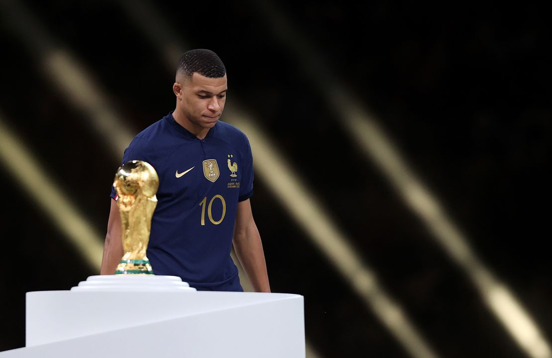 LUSAIL CITY, QATAR - DECEMBER 18: Kylian Mbappe of France walks past the FIFA World Cup trophy as he looks dejected following his teams loss in the FIFA World Cup Qatar 2022 Final match between Argentina and France at Lusail Stadium on December 18, 2022 in Lusail City, Qatar. (Photo by Julian Finney/Getty Images)