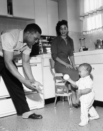 Mays, then of the San Francisco Giants, plays catch with 14-month-old Herbert Henderson, at the home of Henderson's parents, in San Francisco, California on November 14, 1957. Mays was staying with the Henderson's while house hunting.