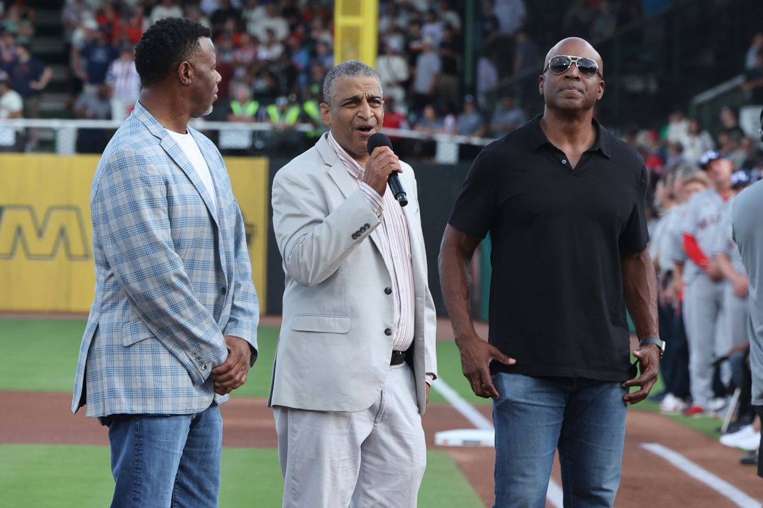 Willie Mays' son, Michael Mays, addresses the crowd aside baseball greats Ken Griffey Jr., left, and Barry Bonds, right.