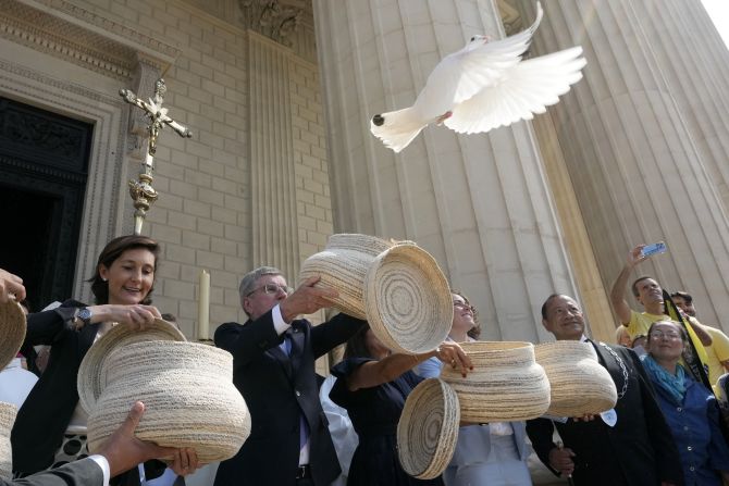 French Minister of Sports and Olympic and Paralympic Games Amélie Oudéa-Castéra, left, and International Olympic Committee President Thomas Bach, center, release doves after a Mass in Paris on July 19.