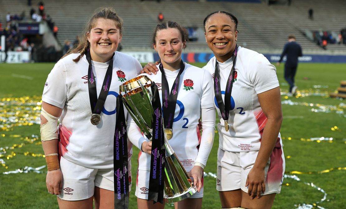 Kabeya (R) and her England teammates Maud Muir (L), Lucy Packer pose with the Six Nations trophy.