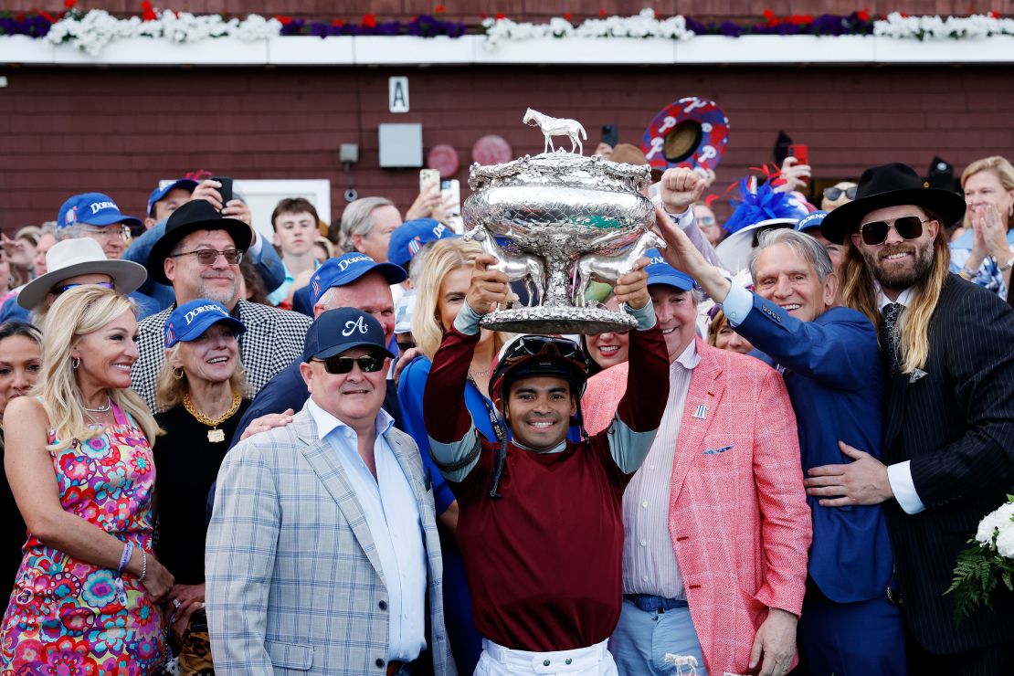 Jockey Luis Saez raises the trophy after Dornoch wins the 156th running of the Belmont Stakes.